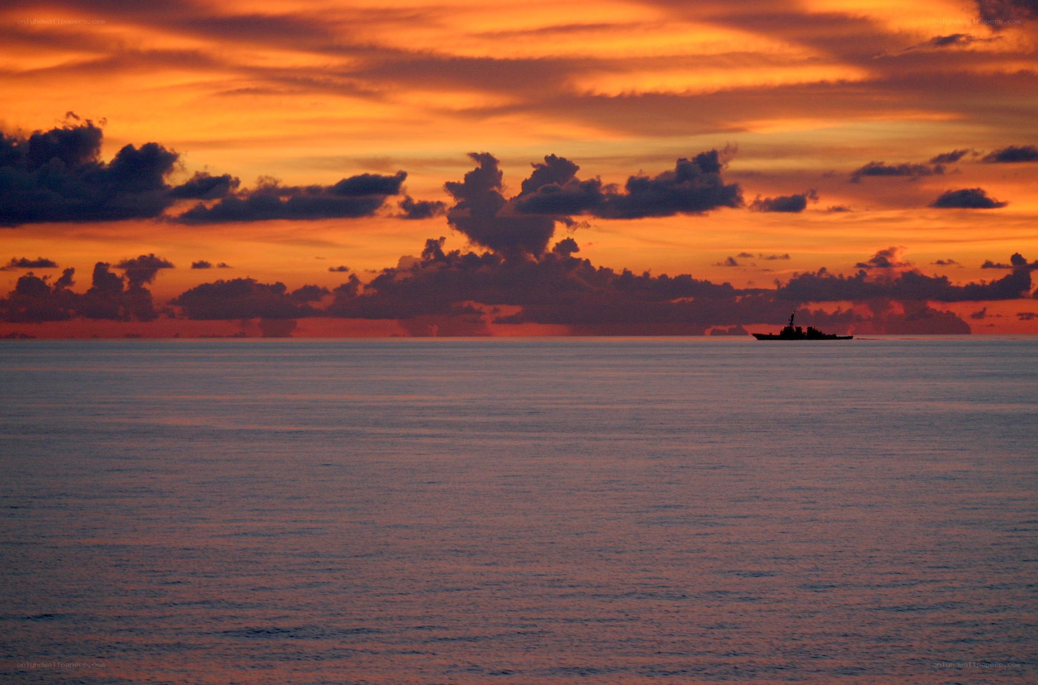 Sunset over the ocean with a ship