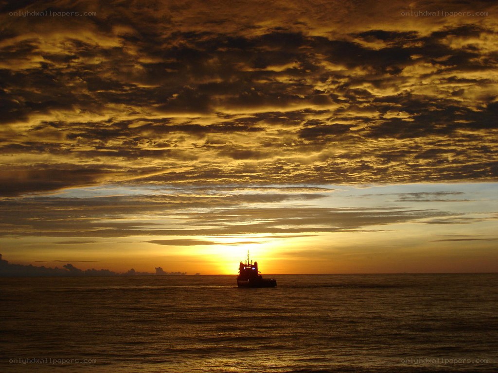 Sunset over the ocean with a ship