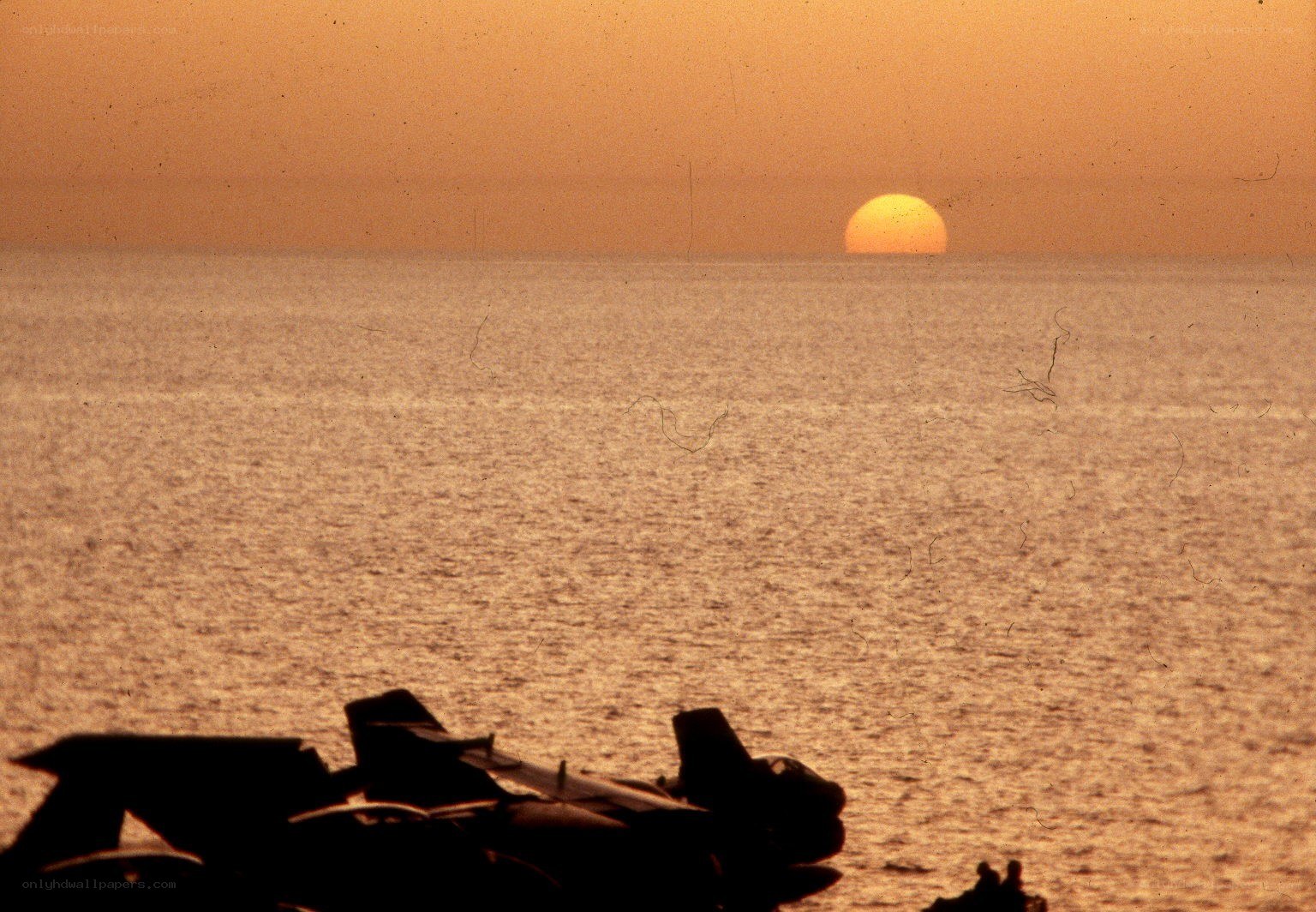 Sunset over the ocean with aircraft