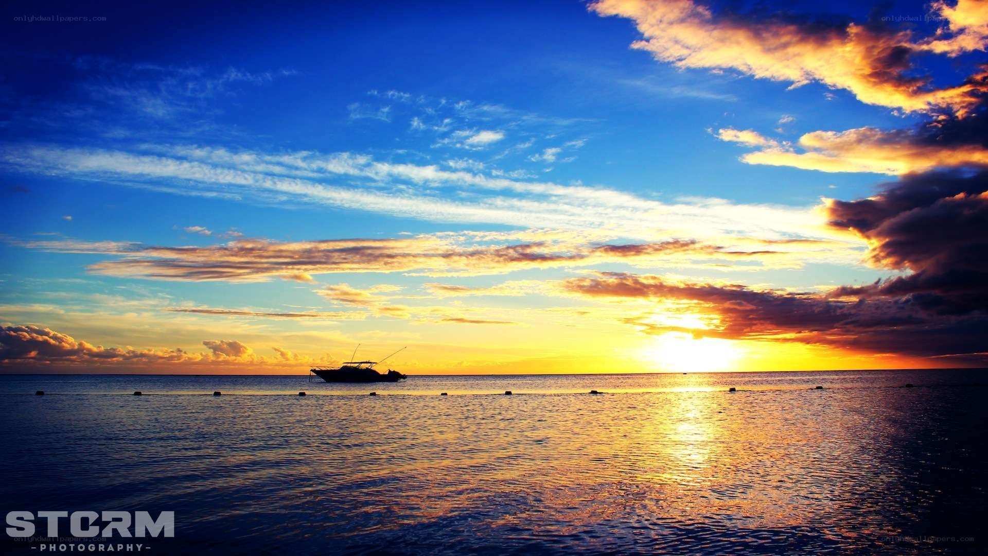sunset over the ocean with boat
