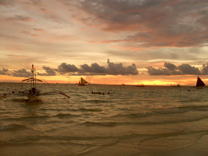 Sunset over the ocean with boats