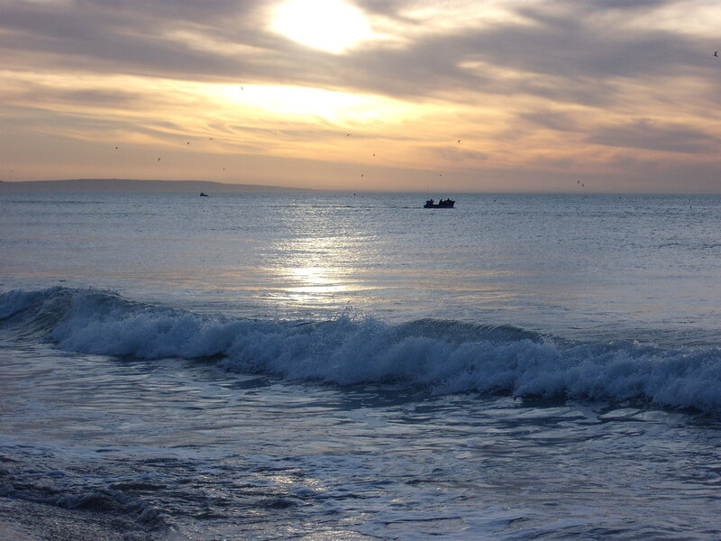 Sunset over the ocean with boats