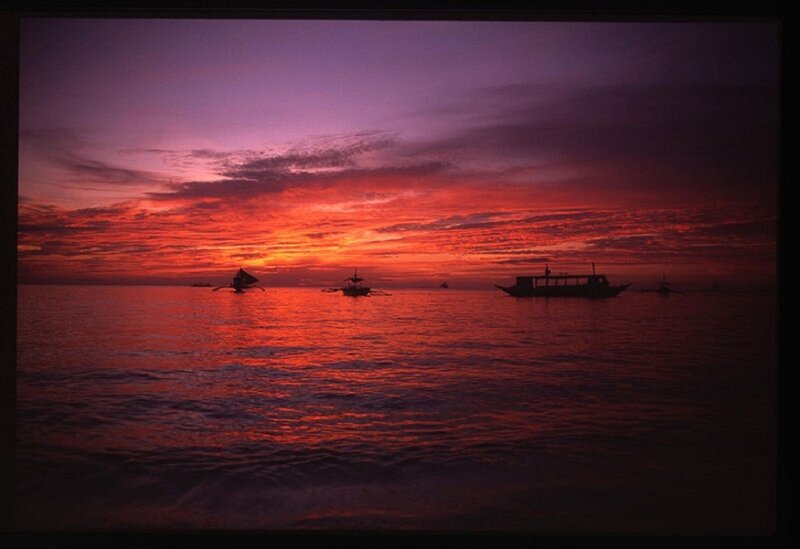 Sunset over the ocean with boats