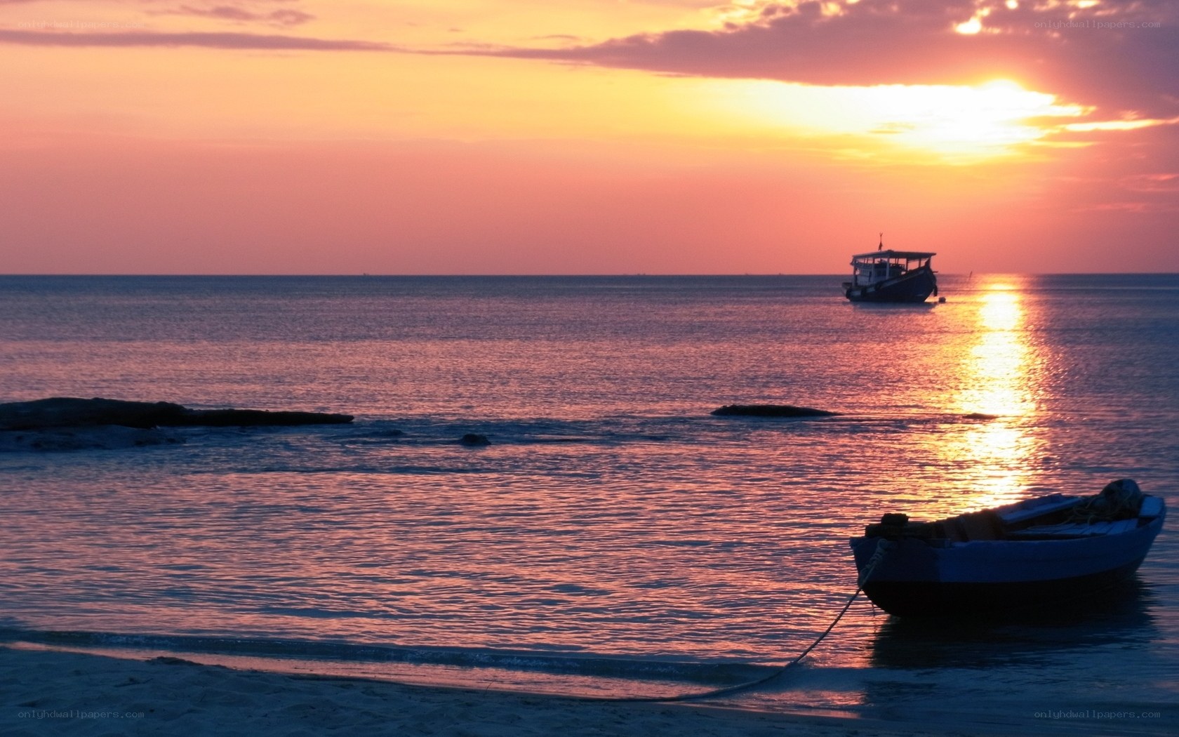 Sunset over the ocean with boats
