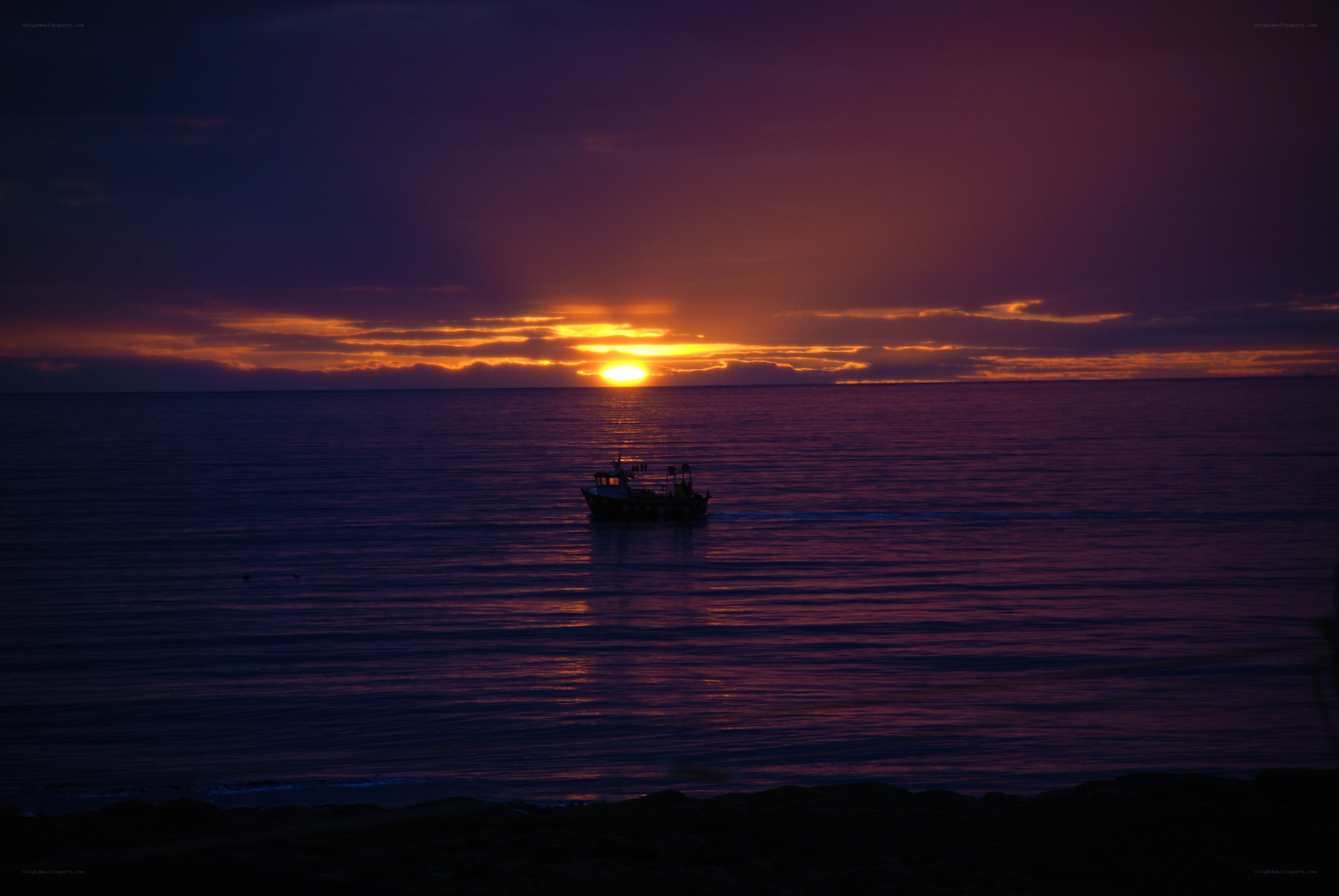 Sunset over the sea with a boat