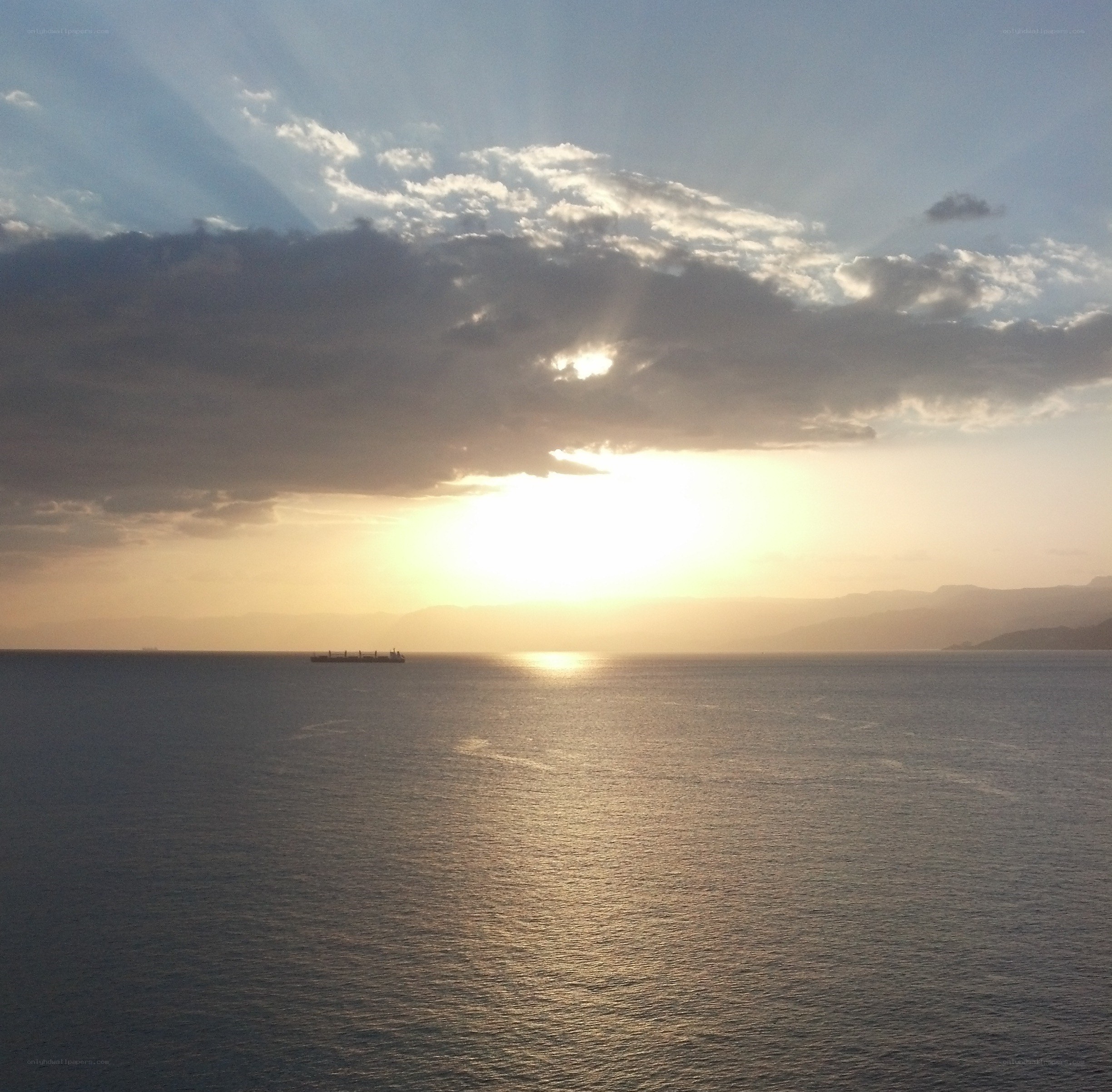 Sunset over the sea with a ship
