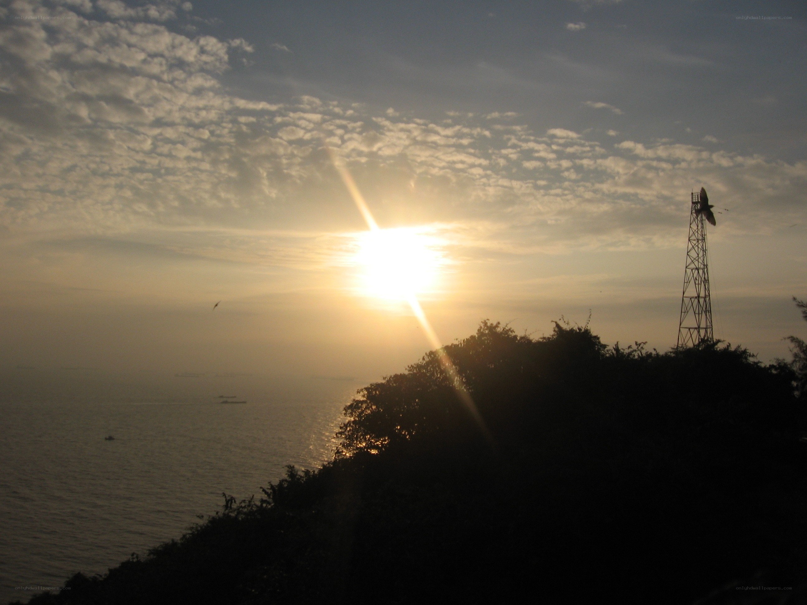 Sunset over the sea with a tower