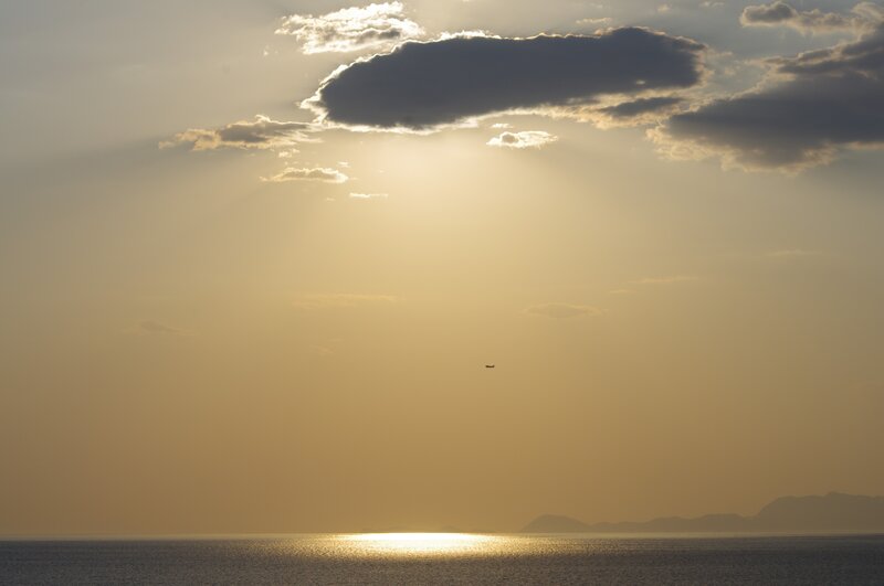 Sunset over the sea with airplane