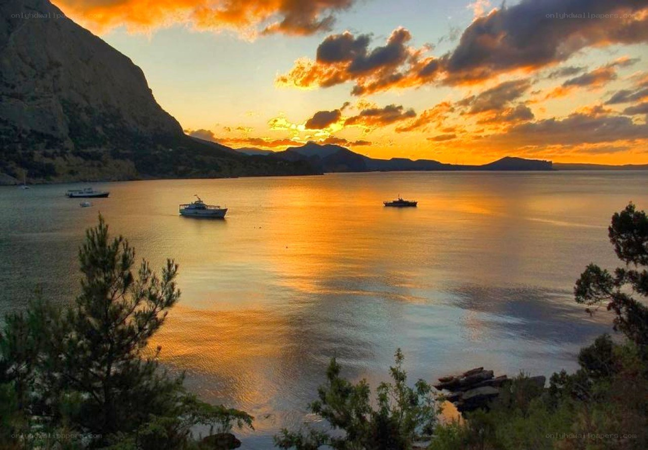 Sunset over the sea with boats
