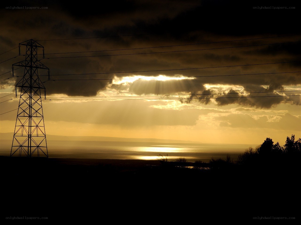 Sunset over the sea with power lines