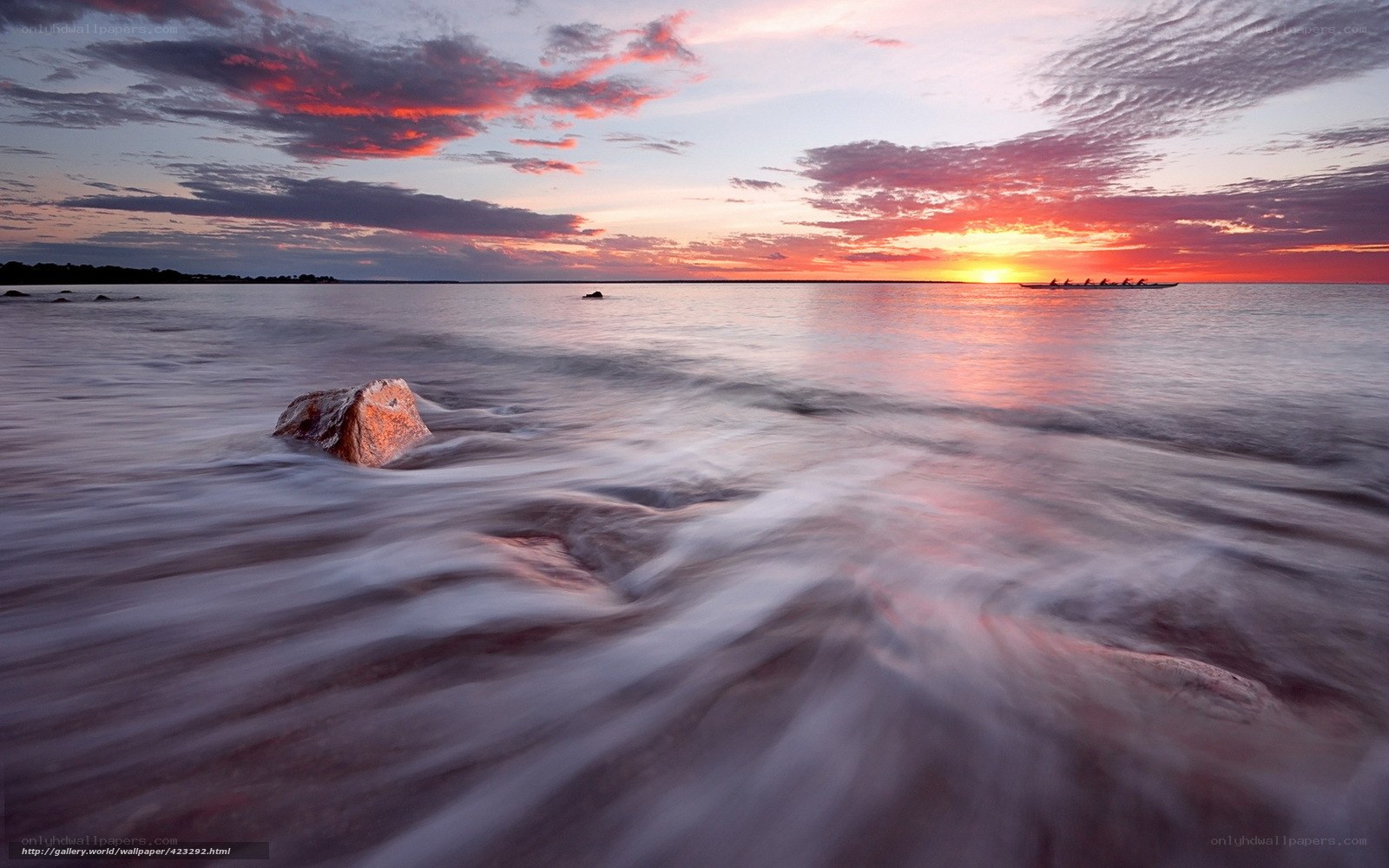 Sunset over the sea with rowers