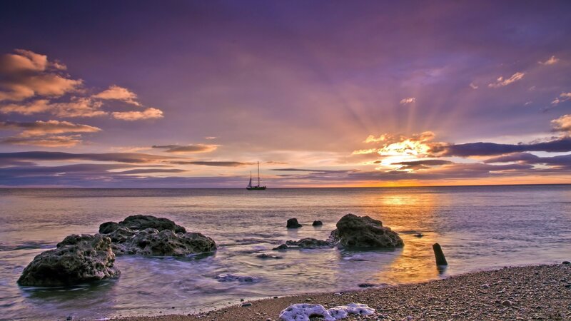 Sunset over the sea with sailboat