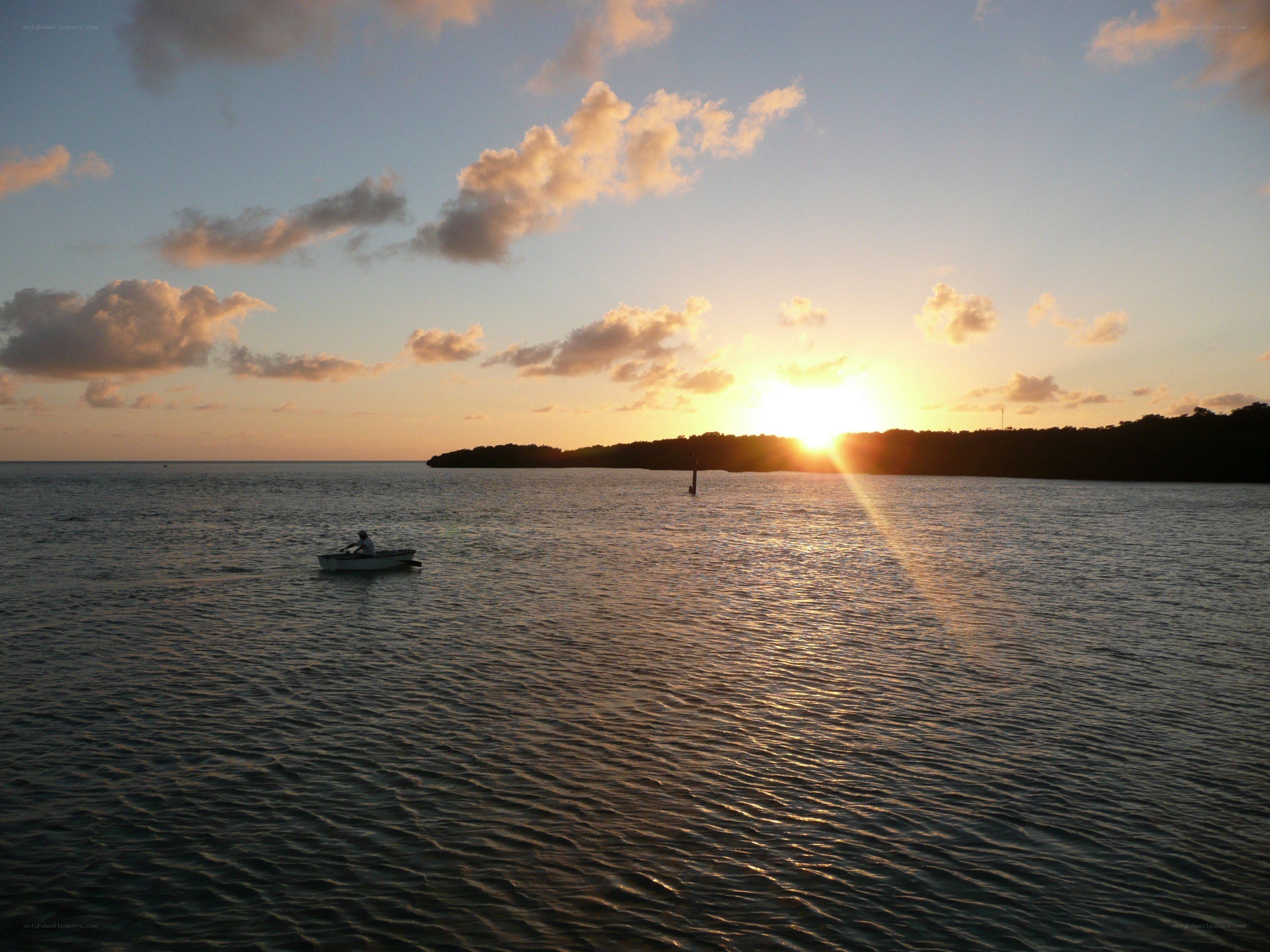 Sunset over the water with a boat