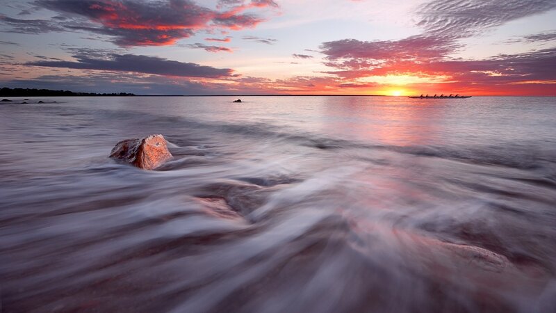 Sunset over the water with a canoe