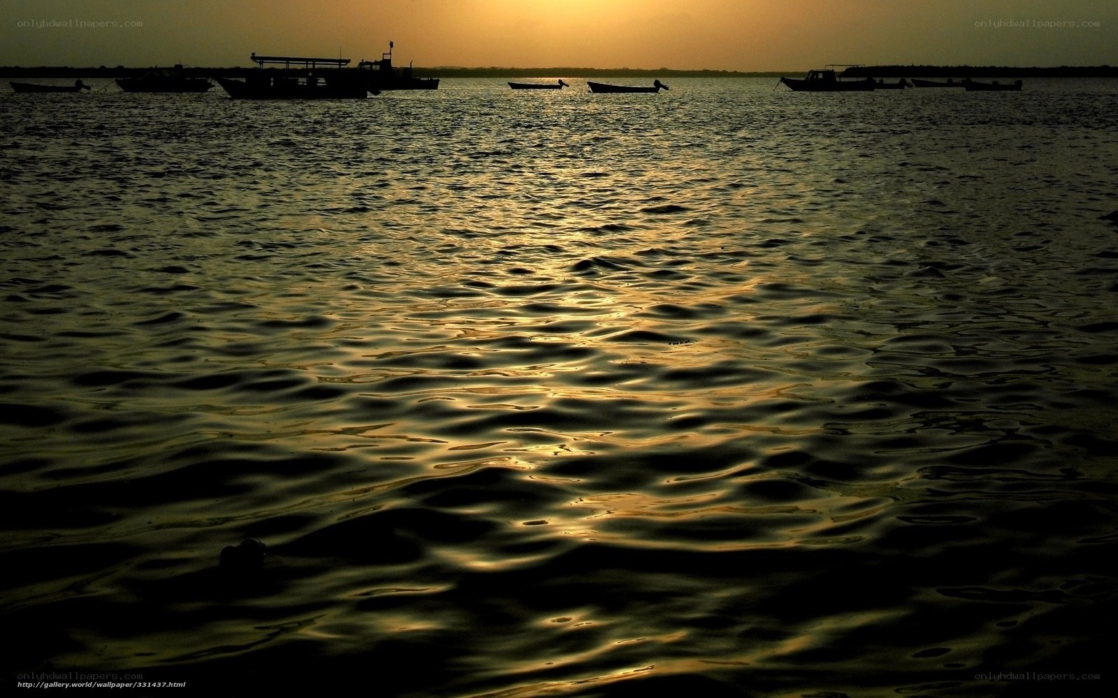 Sunset over the water with boats