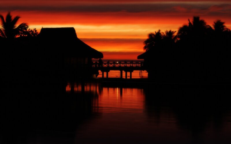 sunset over tropical bungalows