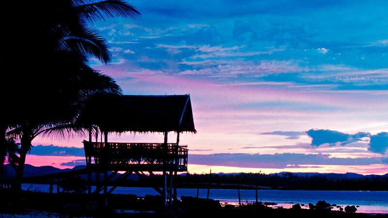 sunset over tropical hut
