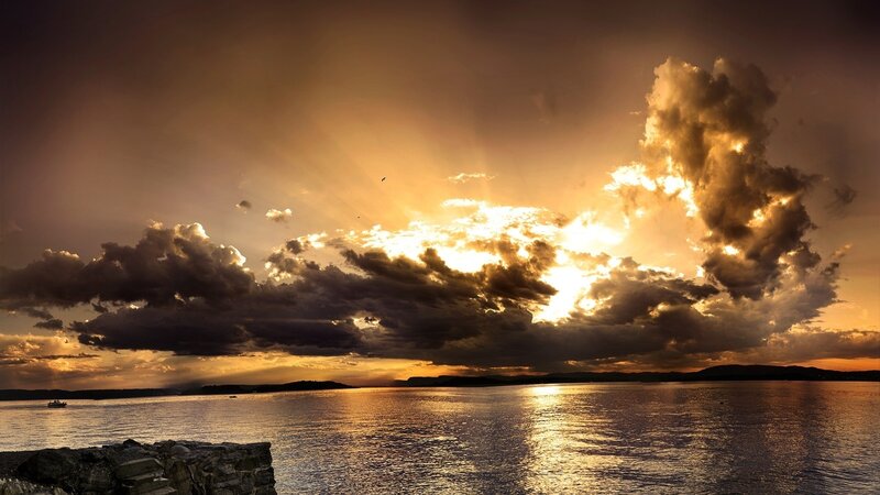 Sunset over Water — Gold, Dramatic, Photograph, Clouds, Boat, Stone Wall