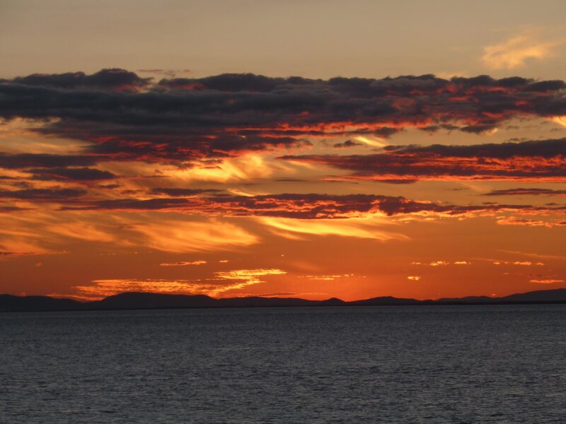 Sunset over Water — Orange, Dramatic, Photograph, Clouds, Mountains