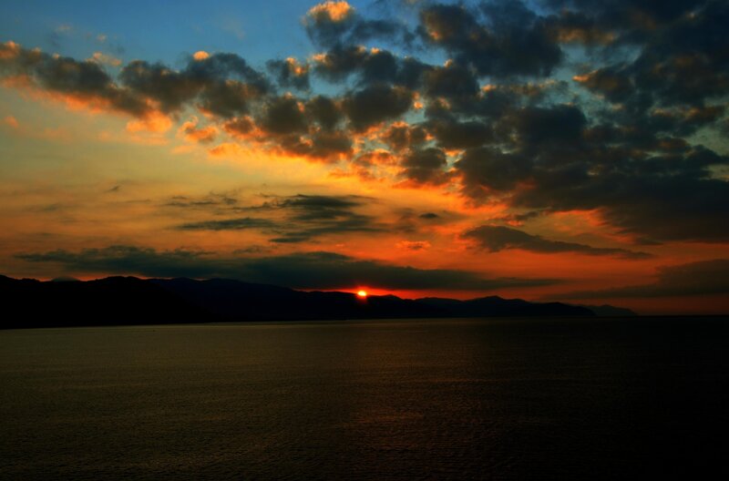 Sunset over Water — Orange, Dramatic, Photograph, Mountains, Clouds, Blue