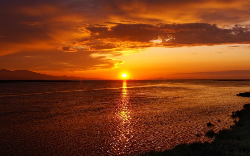 Sunset over Water — Orange, Dramatic, Photograph, Mountains, Clouds, Reflection