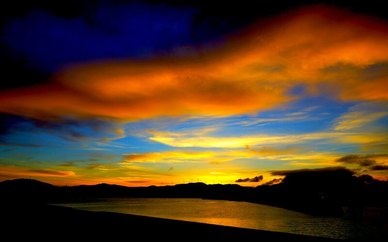 Sunset over Water — Orange, Dramatic, Photograph, Mountains, Clouds, Wind Turbines