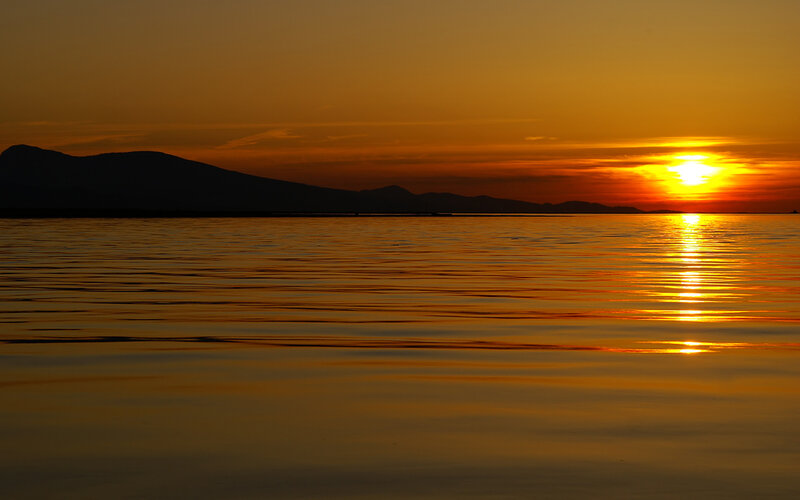Sunset over Water — Orange, Serene, Photograph, Mountains, Sun, Sky, Yellow