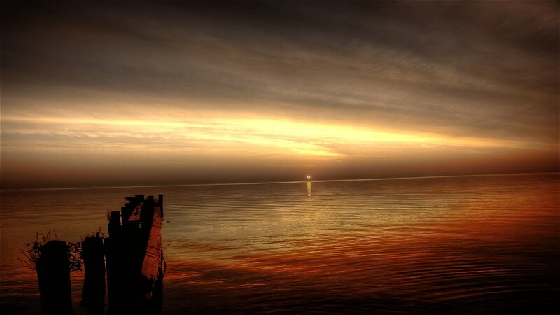 Sunset over Water — Orange, Serene, Photograph, Sun, Clouds, Wooden Posts