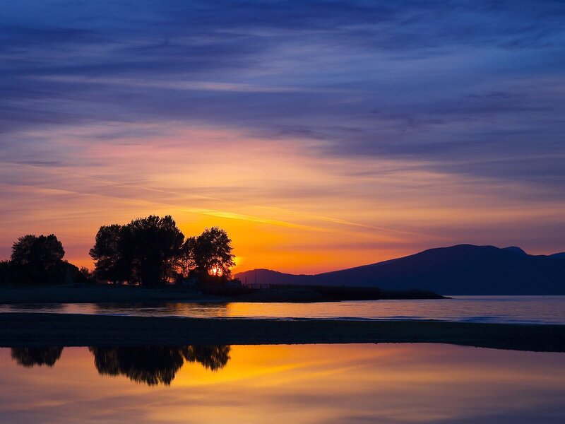 Sunset over Water — Orange, Serene, Photograph, Trees, Mountains, Reflection, Purple
