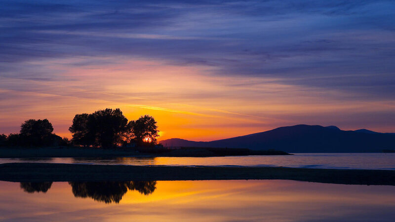 Sunset over Water — Orange, Serene, Photograph, Trees, Mountains, Reflection
