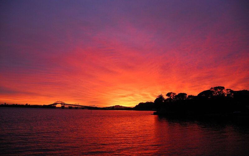 Sunset over Water — Red, Dramatic, Photograph, Bridge, Trees, Sky