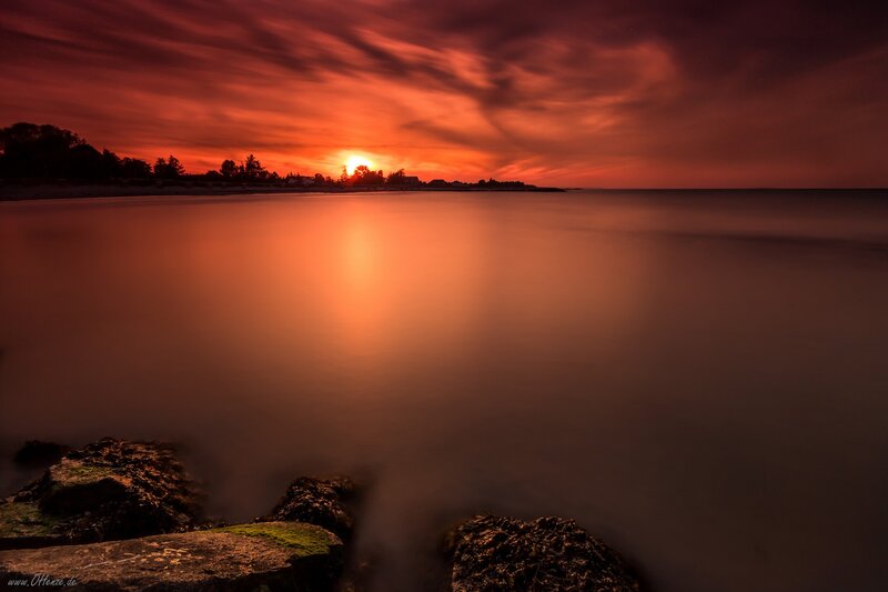 Sunset over Water — Red, Dramatic, Photograph, Sky, Rocks, Trees