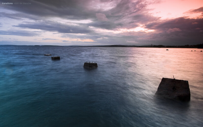 Sunset over water with concrete blocks