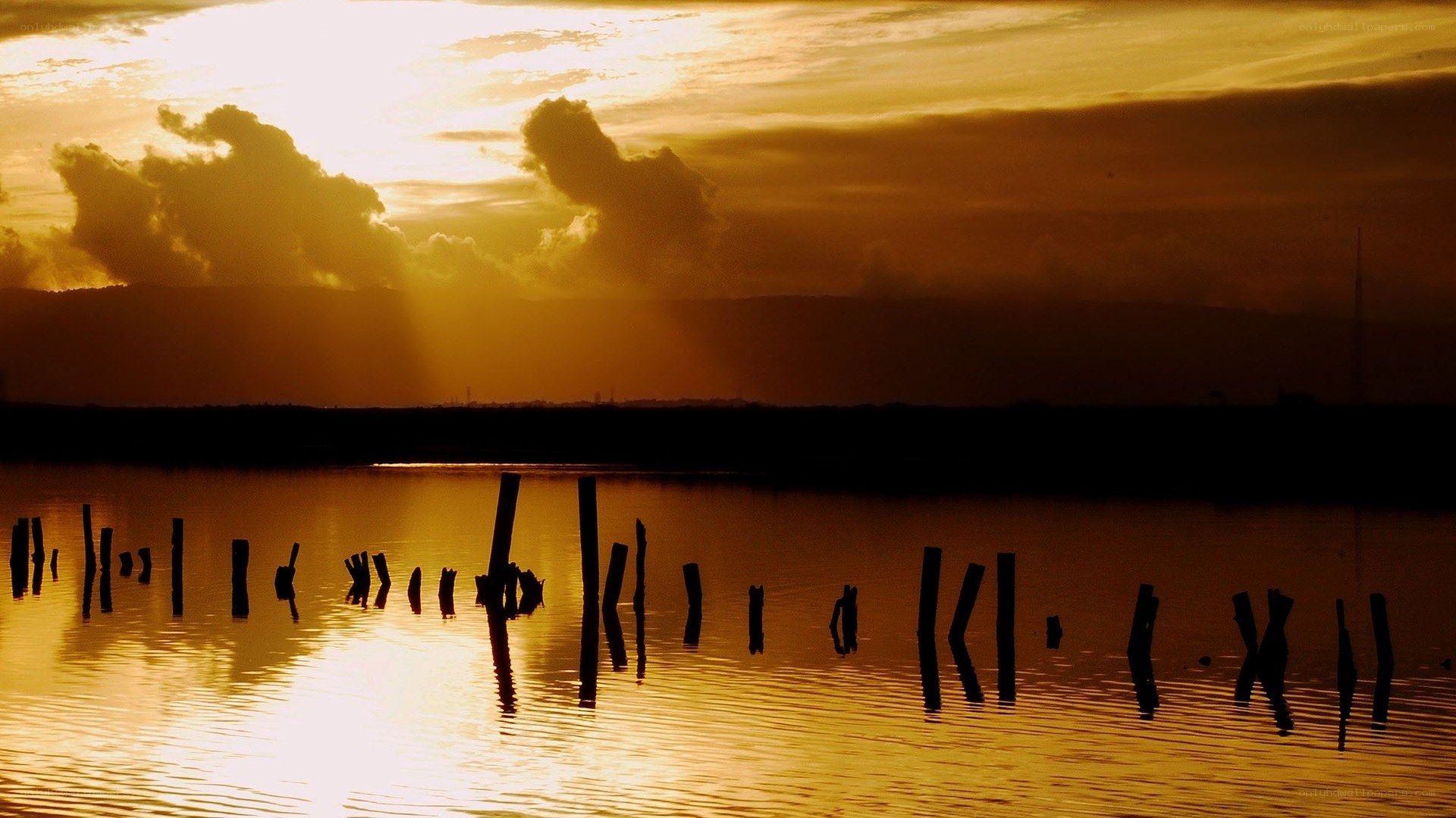 sunset over water with pilings
