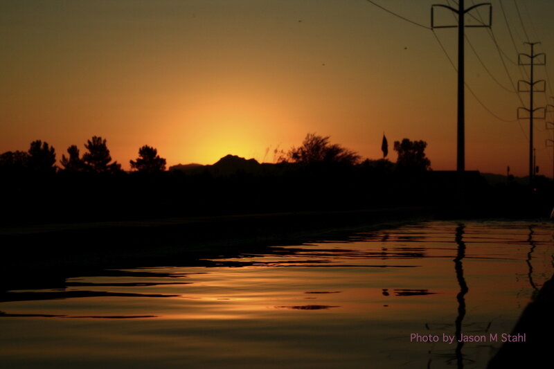 sunset over water with silhouettes