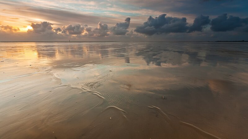 sunset over wet sand
