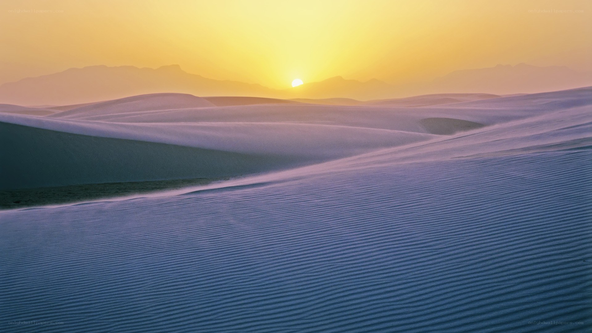 Sunset over white sand dunes