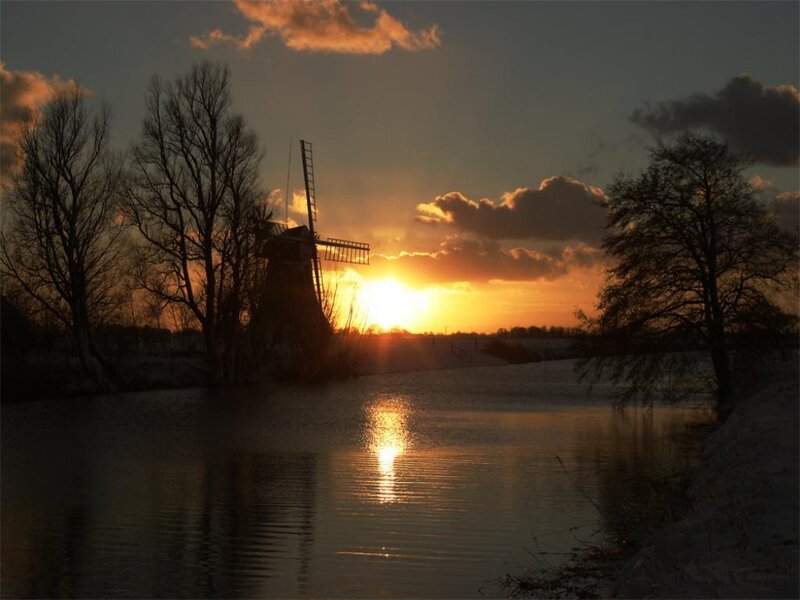 sunset over windmill and river