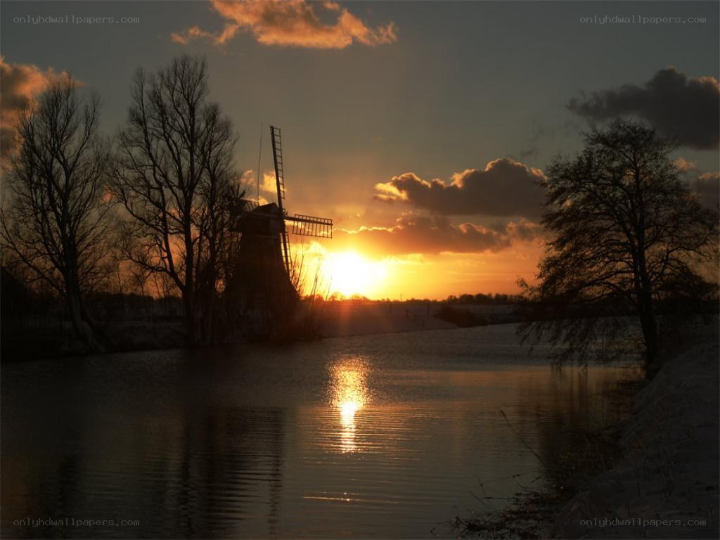 sunset over windmill and river