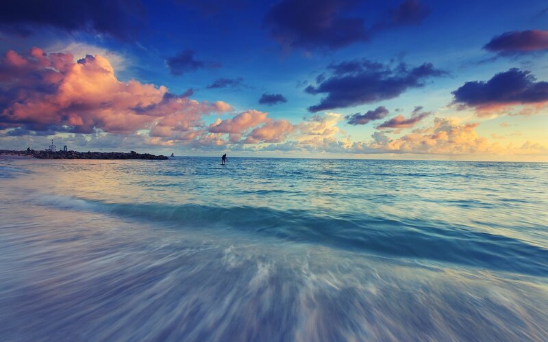 Sunset paddleboarding at sea