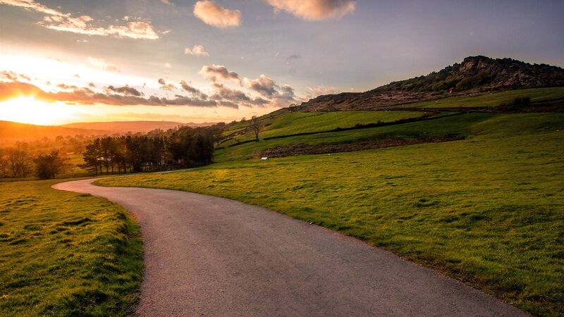 Sunset path through green hills