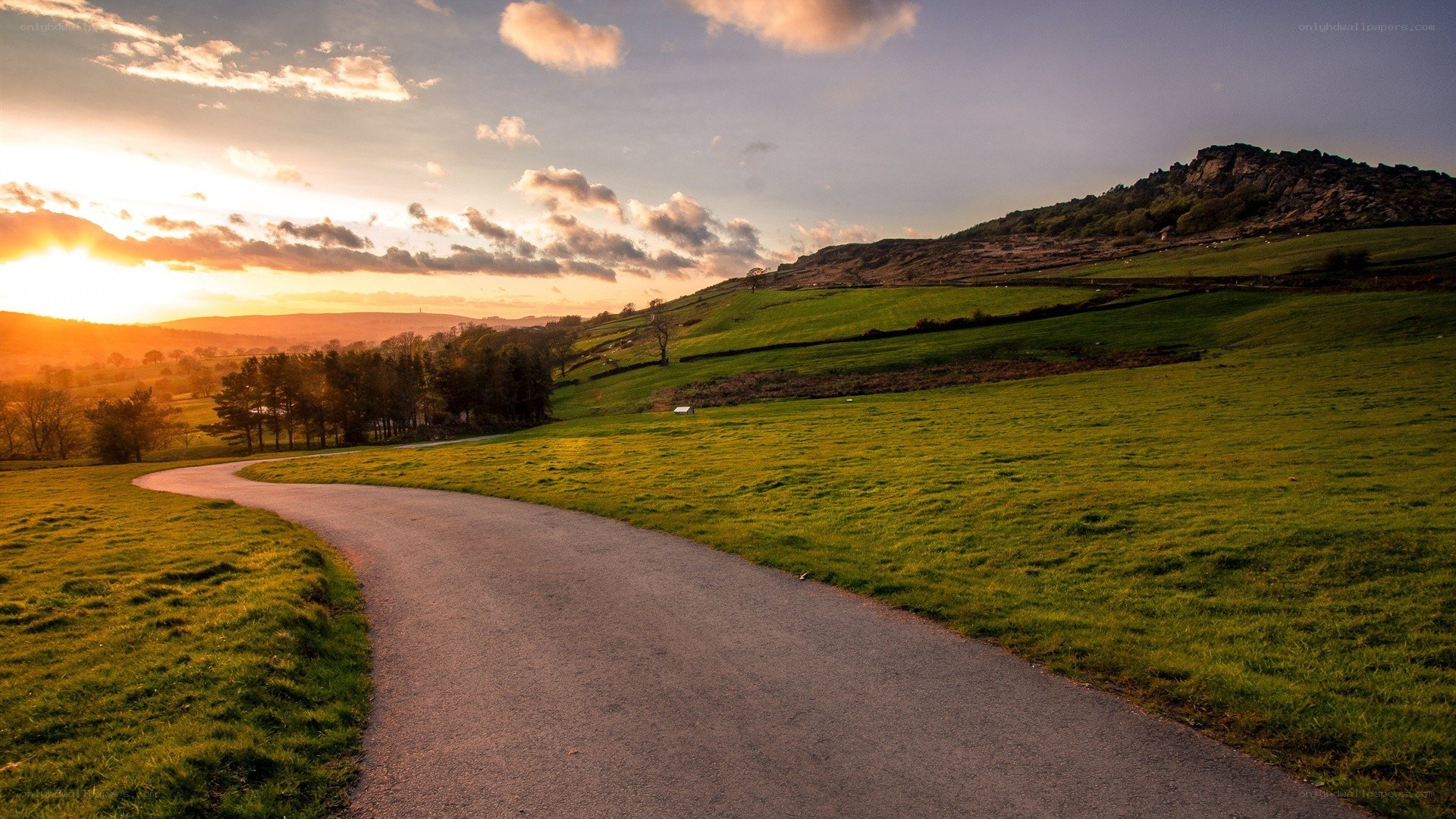 Sunset path through green hills