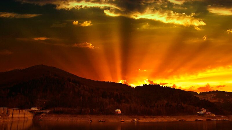 Sunset rays over mountain lake