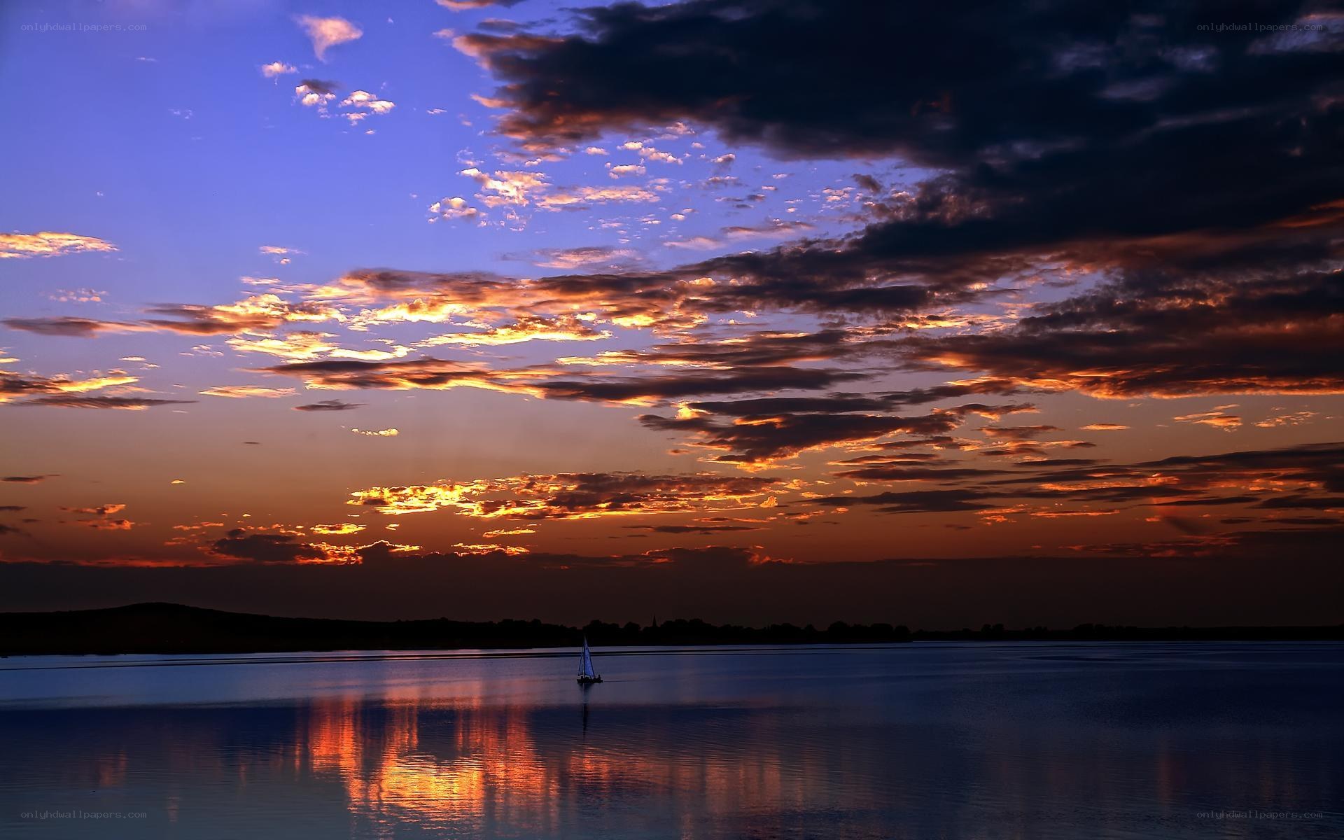 sunset sailboat on calm water