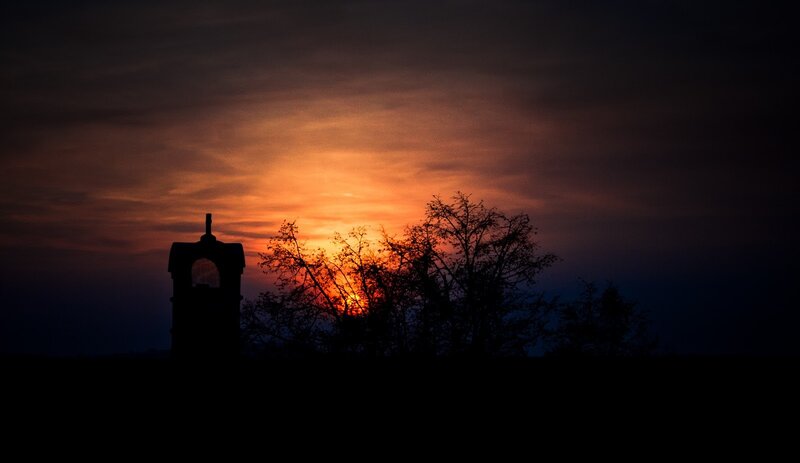 Sunset silhouette of tower and trees