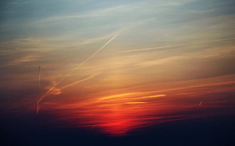 Sunset sky with airplane trails