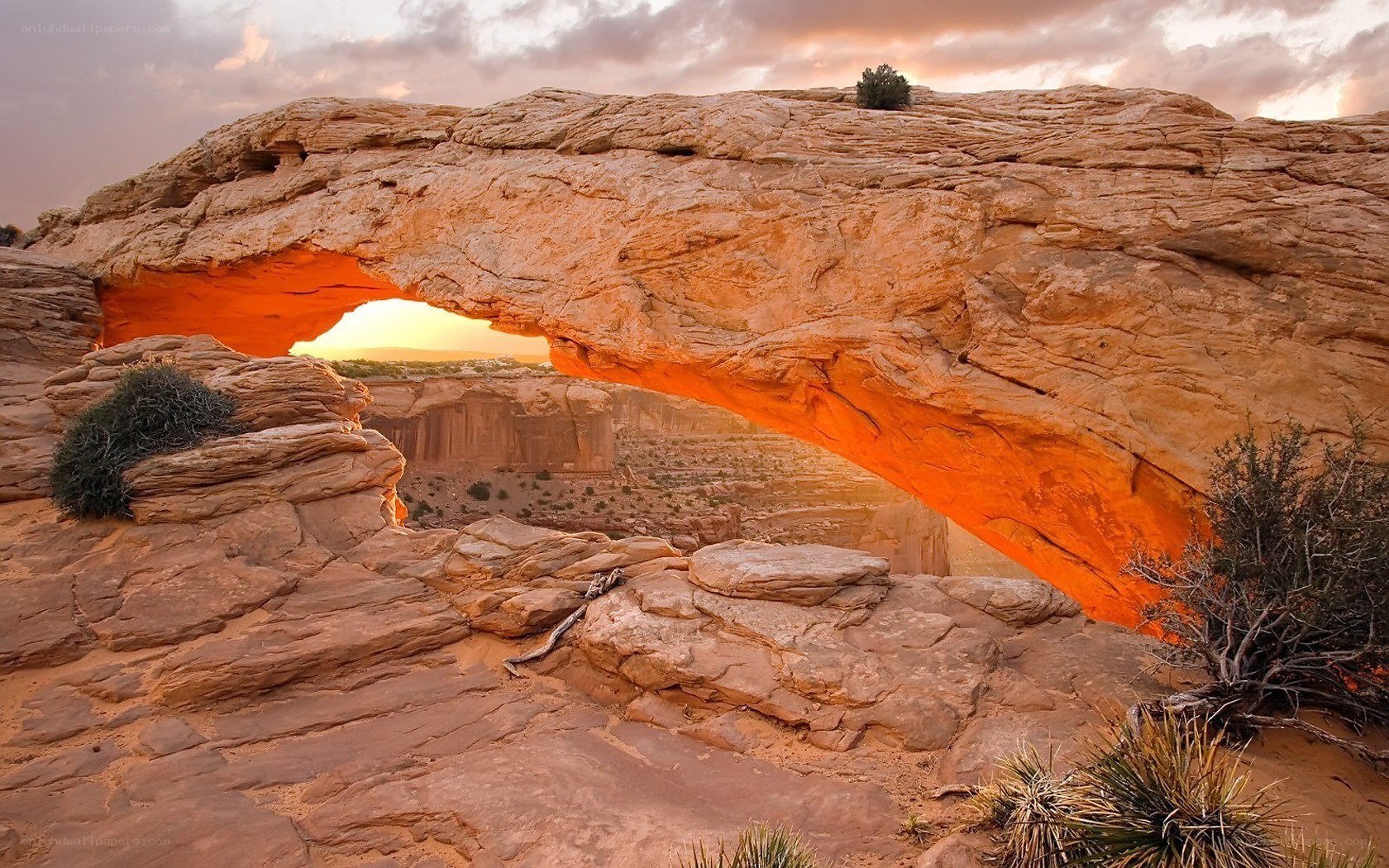 Sunset through a natural rock arch