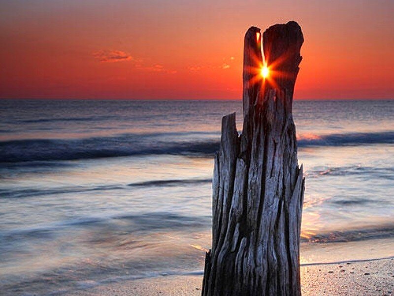 Sunset through a wooden post