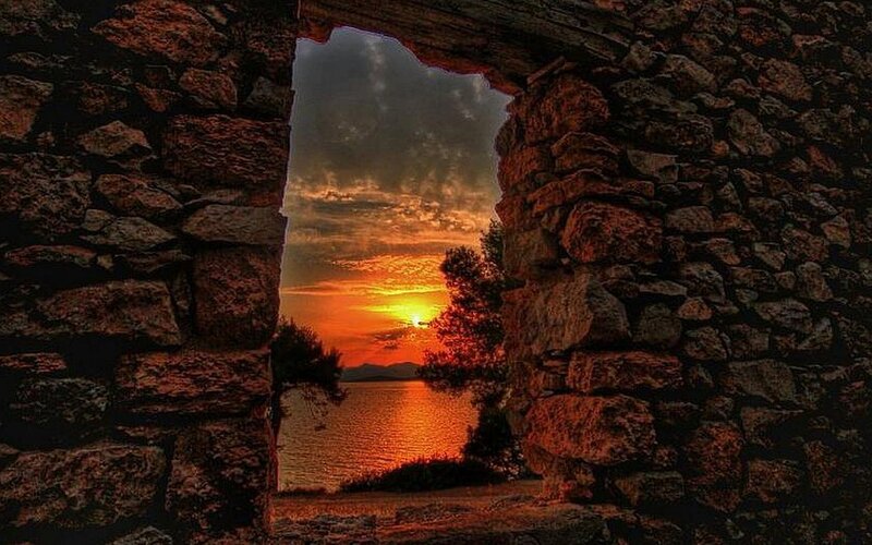 sunset through stone arch