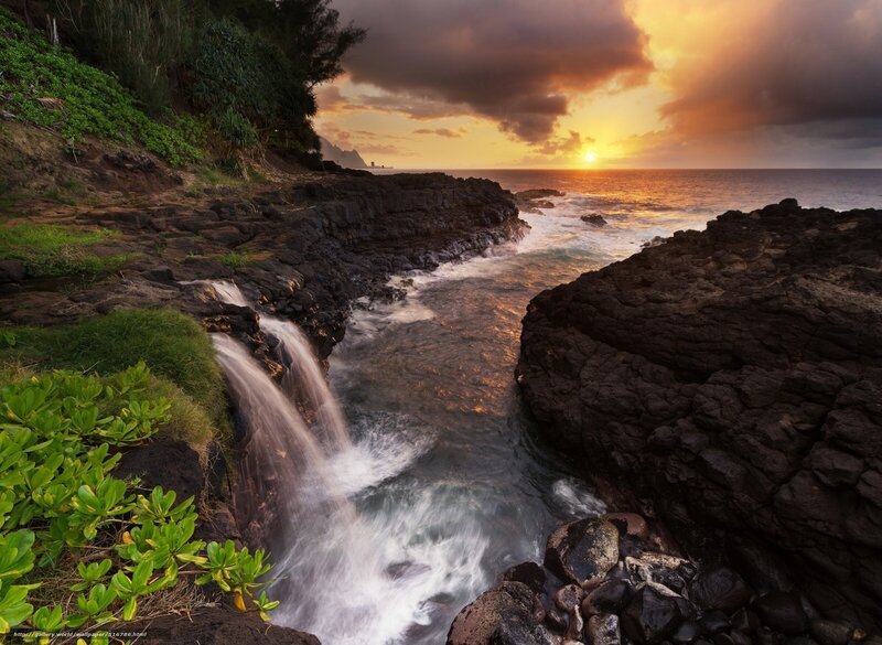 Sunset waterfall at coastal cliffs